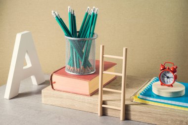 Kalemler, kitaplar ve çalar saatle okul yaratıcı konseptine geri dönelim. Modern natürmort