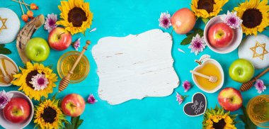 Yahudi bayramı Rosh Hashana, bal, elma ve ayçiçekleriyle dolu mavi ahşap masa. Yukarıdan yukarıdan bir görüntü. İbranice metin 