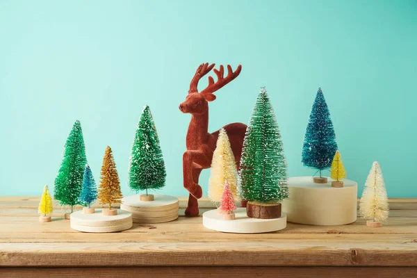 Kerstdecor Concept Met Kleurrijke Kerstbomen Rendieren Houten Tafel Blauwe Achtergrond — Stockfoto