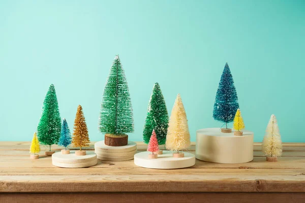 Weihnachtsdekor Konzept Mit Bunten Weihnachtsbäumen Auf Holztisch Vor Blauem Hintergrund — Stockfoto