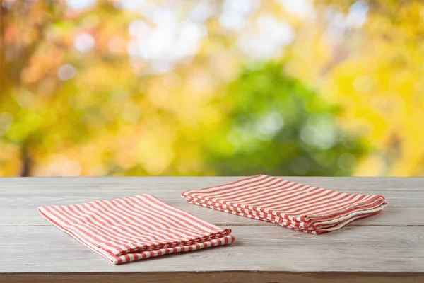 秋のボケの背景に縞模様のテーブルクロスを空の木製のテーブル デザインのための食品や製品の表示モックアップ — ストック写真