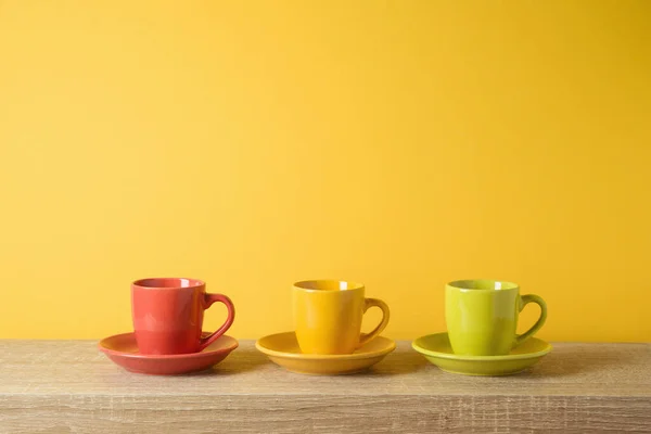 Kahve Fincanları Ahşap Rafta Sarı Duvarın Arkasında — Stok fotoğraf