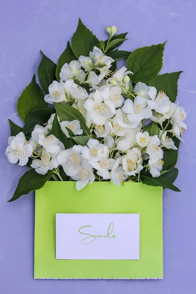 Bouquet of fresh jasmine with neon green paper and smile lettering