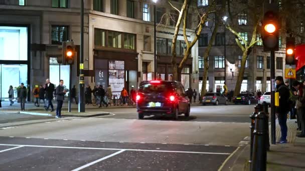2020年2月3日 在伦敦经济学院外 一个行人过马路的信号灯转红 车辆停放 行人在夜间穿过马路 — 图库视频影像