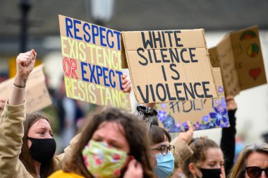 Richmond, North Yorkshire, UK - June 14, 2020: Protesters wear PPE face masks and hold homemade anti racism signs high at a Black Lives Matter protest in Richmond, North Yorkshire clipart