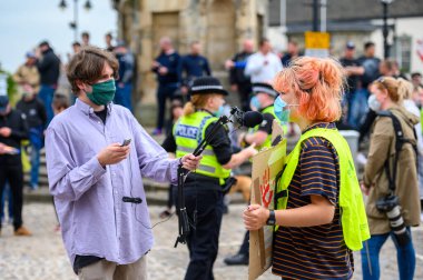 Richmond, Kuzey Yorkshire, İngiltere - 14 Haziran 2020: Bir adam PPE Yüz Maskesi takıyor ve bir Siyahi Yaşamı Önemi Protestocusuyla röportaj yaparken mikrofon tutuyor