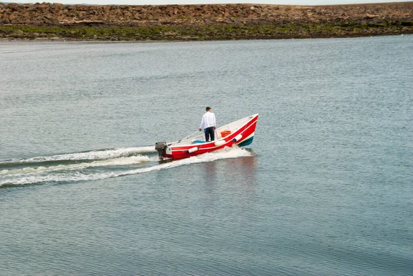 穏やかな日に小さな赤いモーターボートの中に立つ男 — ストック写真