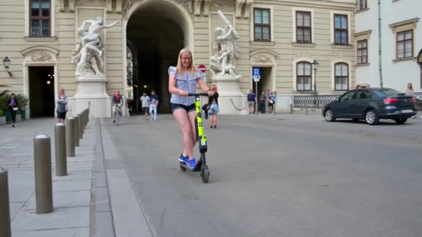 ウィーン 2019年7月11日 幸せな若い女性が オーストリア ウィーンのホフブルクを通ってレンタル電動スクーターに乗る — ストック動画