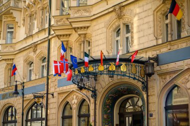 PRAG - 20 Temmuz 2019 Prag, Çek Cumhuriyeti 'ndeki eski bir otel binasının girişinde ulusal bayraklar