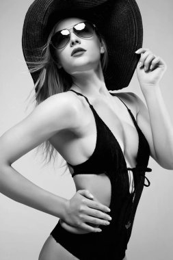 Şapka ve güneş gözlüğü güzel kadın. tek renkli moda şık sarışın kız portresi