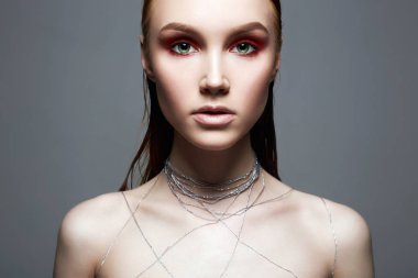 Güzellik makyaj kız portakal göz farı ile. Makyaj ve vücut üzerinde gümüş iplik ile güzel genç kadın