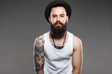 Sakallı yakışıklı şapkalı. Acımasız hipster çocuk dövme ile
