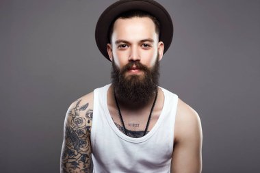 Sakallı yakışıklı şapkalı. Dövme yandan acımasız hipster çocukla