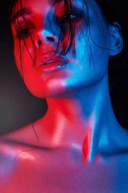 Bir kızın yüzü parlak renk. Gökkuşağı renkli parlak ışıklar Studio kadında. Sanat tasarım, renkli kız saç ıslak. Vurgulayıcı parlaklık