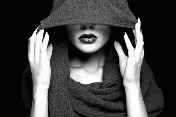 beautiful woman covers her face under hood. part of female face. Black and white portrait
