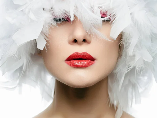 白い羽で美しい少女の肖像画 赤い唇 羽帽子 クローズ アップを持つ若いセクシーな女性 美しさをメイクアップ — ストック写真