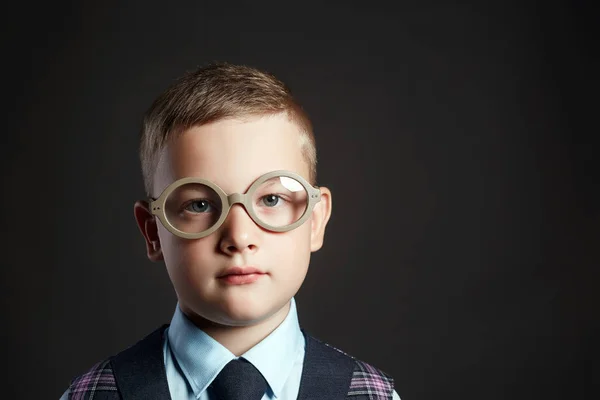 学校の机の近くのメガネで頭の良い子 スーツと黒板で眼鏡の少年 — ストック写真