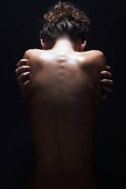 Studio çıplak vücut kız. Çıplak kadın geri karanlıkta. Güzel kadın omurga