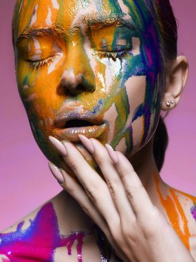 Renk boya kız portresi. bir güzel yüz ve vücut bölgesine akan sıvı boya. Renkler