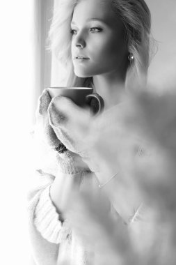 sıcak kahve ile kış ev yaşam kız. güzel sarışın kadın eldivenler, pencere ve Noel ağacı kal