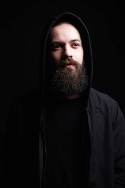 Yakışıklı kaputun içinde sakallı. Şık model çocuk karanlıkta