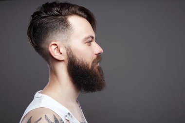 sakallı yakışıklı adam. sakallı hippi. Şık saç kesimi ve dövme bir çocuk