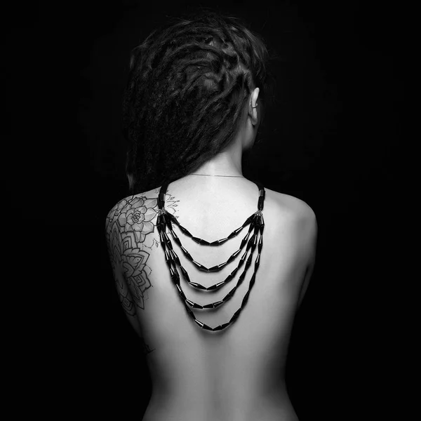 Naken tjej med tatuering och halsband på hennes rygg — Stockfoto