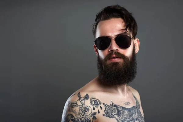 Hombre barbudo en gafas de sol, cuerpo masculino joven tatuado desnudo —  Fotos de Stock