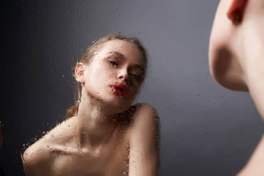 Güzel Genç kadın ıslak aynaya bakıyor