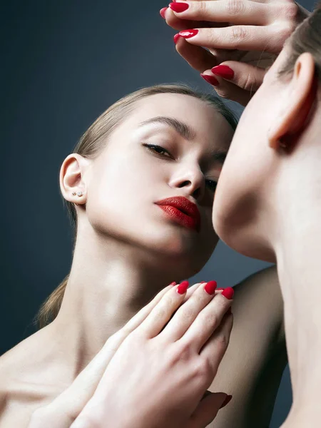 Menina bonita olhando no espelho. maquiagem lábios vermelhos — Fotografia de Stock