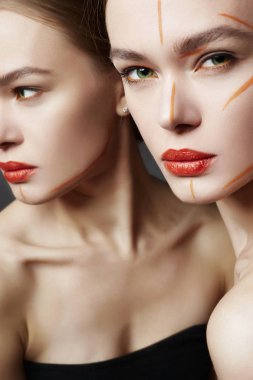 Ayna. Turuncu boya makyajlı genç kadın