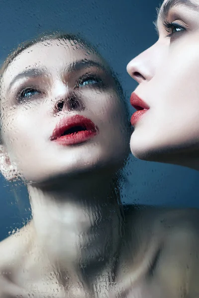 Όμορφο κορίτσι που κοιτάζει σε βρεγμένο καθρέφτη. γυναίκα με κόκκινα χείλη — Φωτογραφία Αρχείου