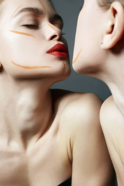 Espelho. Jovem com maquiagem de tinta laranja — Fotografia de Stock
