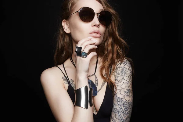 Татуированная девушка в нижнем белье, солнцезащитных очках и украшениях — стоковое фото
