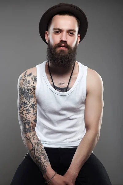 Hombre guapo tatuado con sombrero. Brutal chico hipster — Foto de Stock
