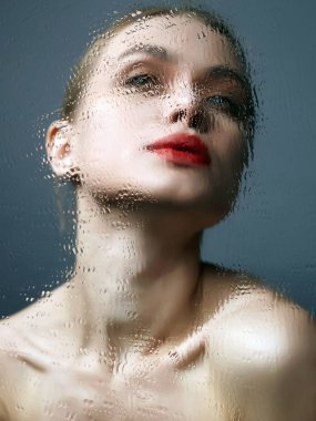 Güzel Kız ıslak aynaya bakıyor. Kırmızı dudaklı genç kadın