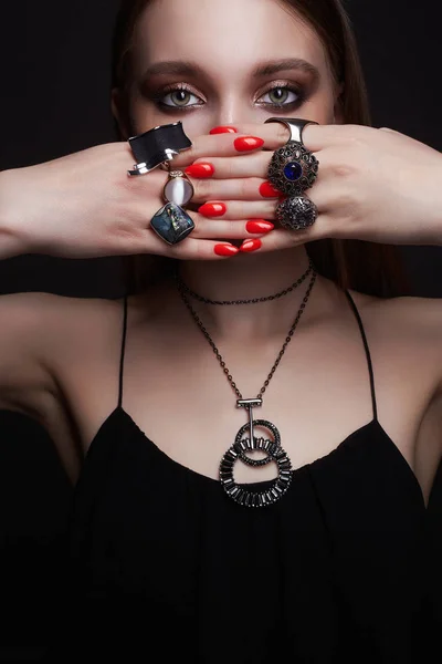 Женские руки с ювелирными кольцами. Красивая девушка с макияжем — стоковое фото