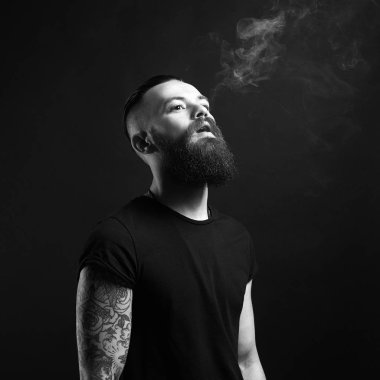 yakışıklı sakallı sigara içen adam. Hipster