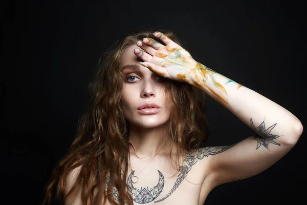 Giovane donna sexy con tatuaggio e vernice a colori — Foto Stock