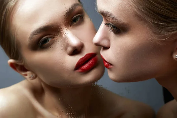 Hermosa chica mirando en el espejo mojado. Sensual mujer joven —  Fotos de Stock