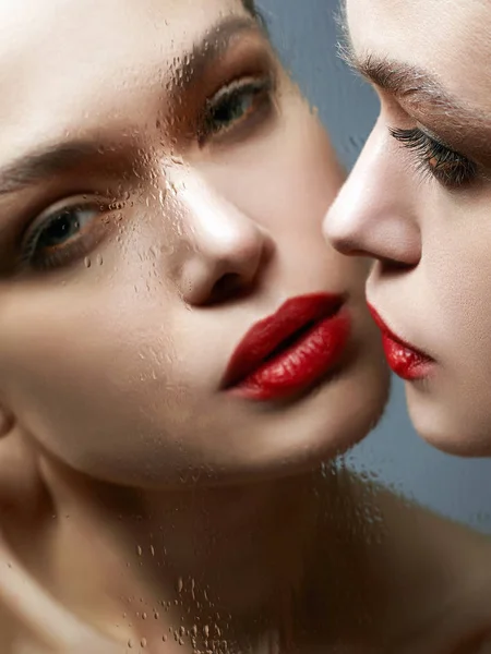 Hermosa chica mirando en el espejo mojado. Sensual mujer joven —  Fotos de Stock