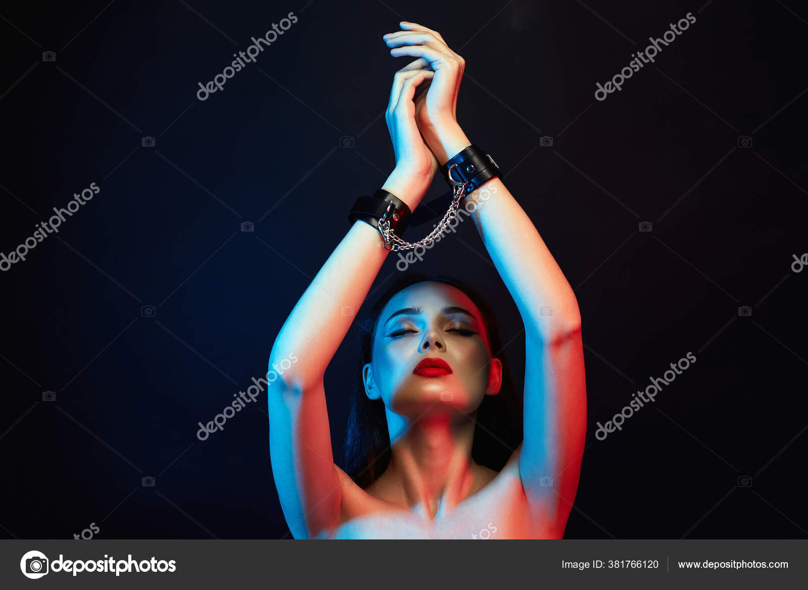 Girl in handcuffs and mask. in color lights. tied hands and