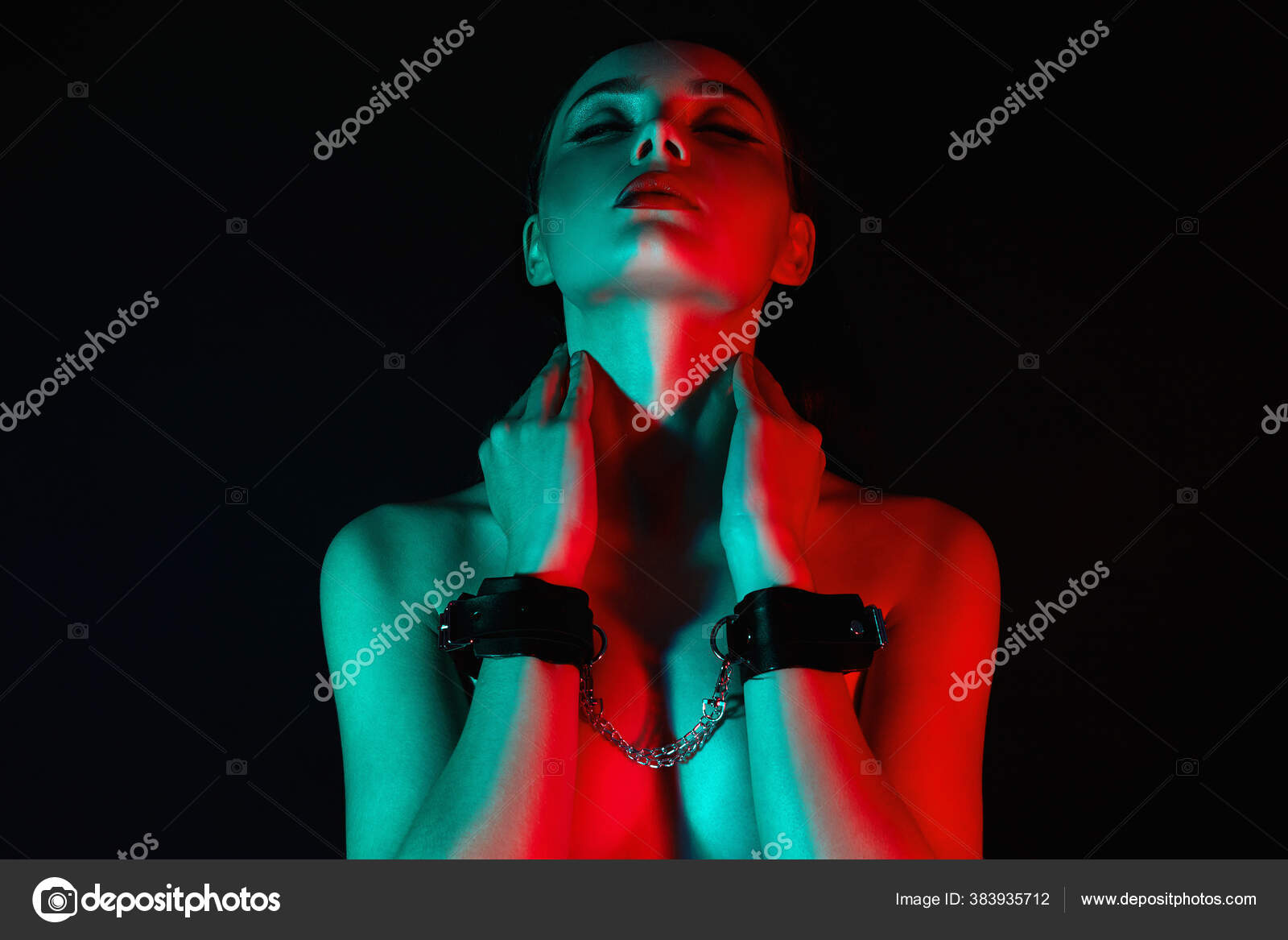 Girl in handcuffs and mask. in color lights. tied hands and