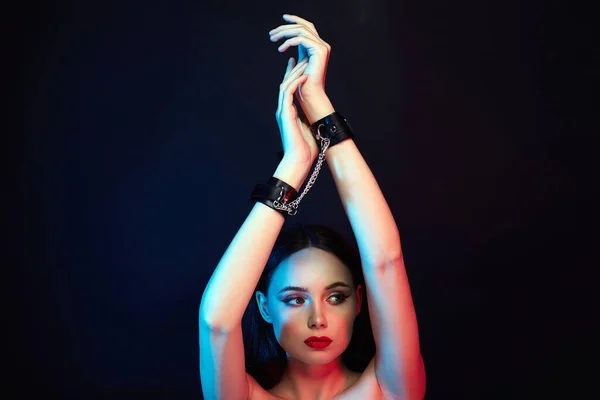 Girl in handcuffs. slave Beautiful young Woman in color lights. Art design, colorful girl with radiance body. tied hands
