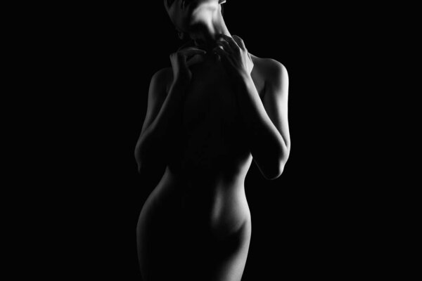 Nude Woman silhouette in the dark. Beautiful Naked Body Girl. Black and white portrait