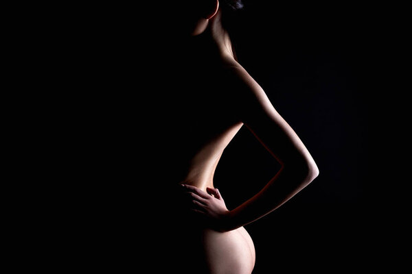Nude Woman silhouette in the dark. Beautiful Naked Body Girl. Back and booty