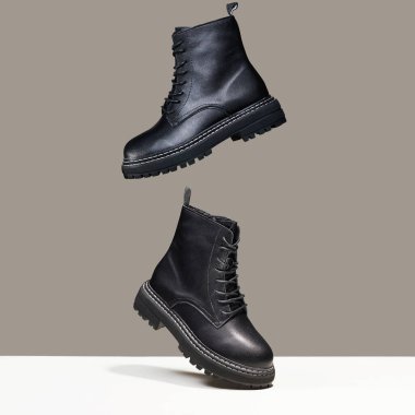 Havada siyah çizmeler var. Moda ayakkabıları hala hayat. Stüdyoda şık bir fotoğraf.