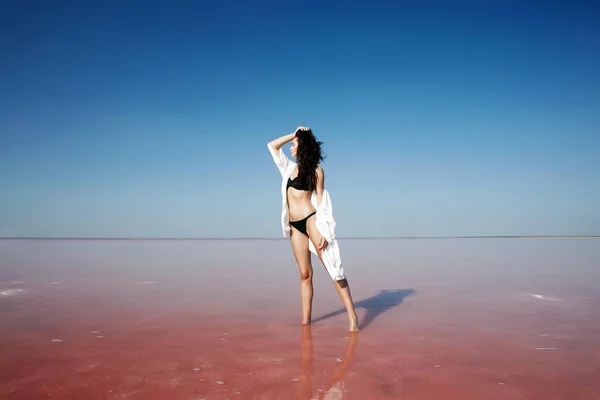 Güzel Bir Kız Pembe Bir Tuz Gölünün Üzerinde Suyun Içinde — Stok fotoğraf