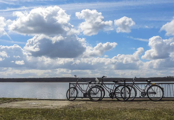 açık bulutlu bir günde göl kenarında park edilmiş bisikletler