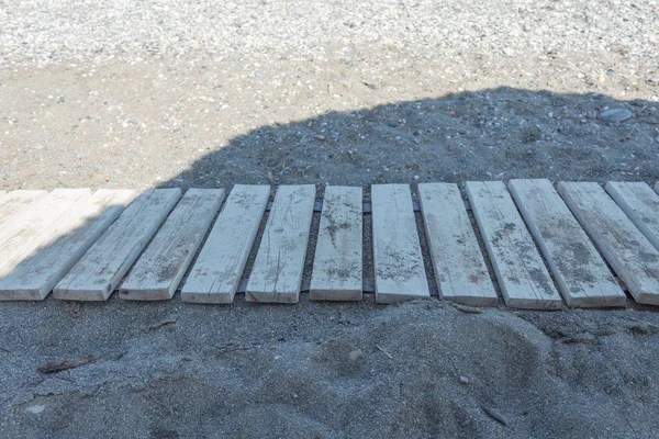 insanlar gelip bu yüzden sıcak kum tarafından yanmış olmadan sahilde ahşap pist